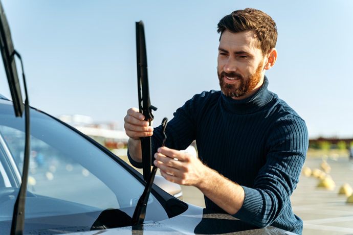man inspecting windshield wipers