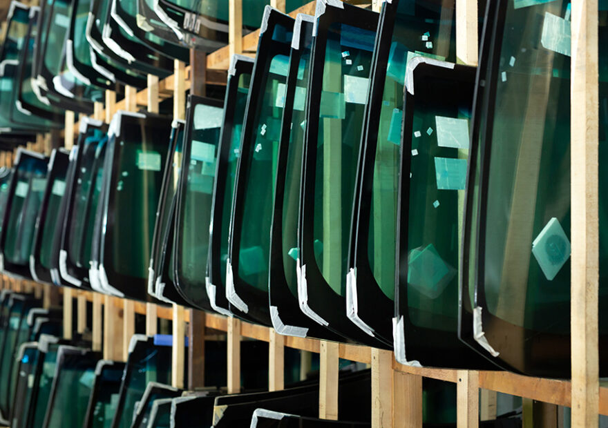 several replacement windshields on a rack