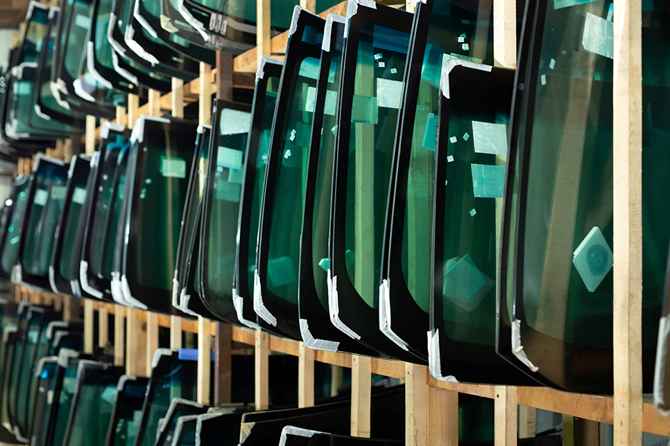 several replacement windshields on a rack