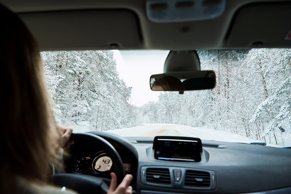 A woman driving on a snowy road in Denver.